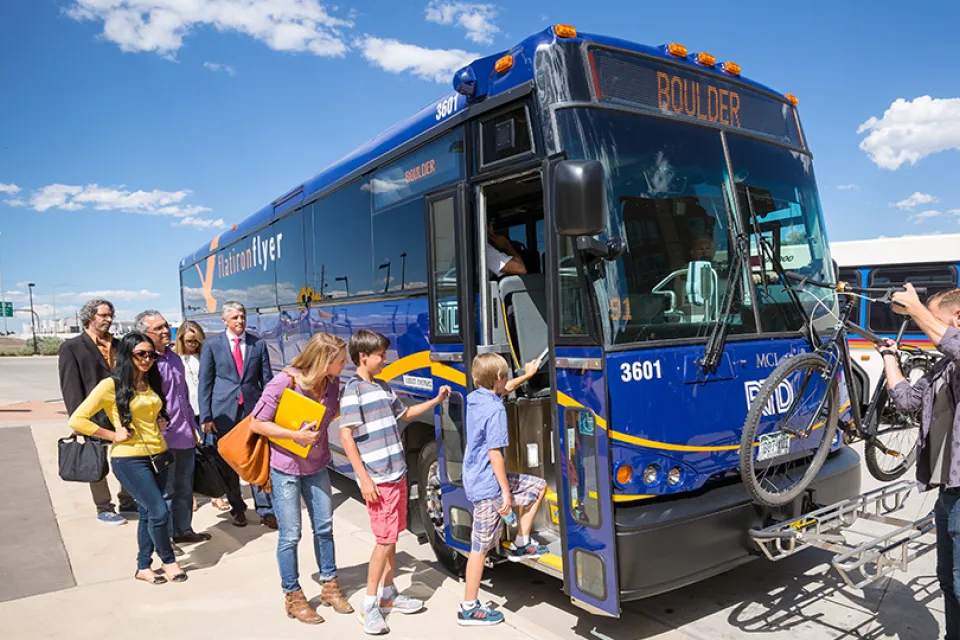 Blue Boulder bus with people boarding